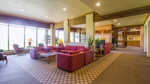 A spacious lobby with a checkered carpet, a red sofa, and a fireplace. - Designer Ski-In / Ski-Out Condominium at the top of Brian Heads Navajo Lift (Brian Head)