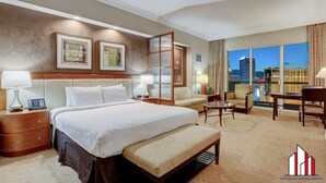 A hotel room with a large bed, a desk, and a view of the cityscape. - MGM Signature-30-705 F1 Track & Strip View Balcony (Las Vegas)