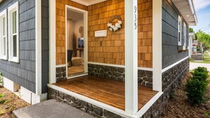 A house with a porch, stone accents, and a wooden wall. - Teresa's Cottage - Walkable to downtown Sturgeon Bay (Sturgeon Bay)
