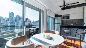 Un apartamento moderno con balcón, comedor y cocina.