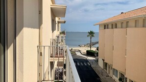 Un balcon avec vue sur une plage et la mer.