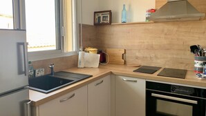 Une cuisine moderne équipée d’un évier, d’une cuisinière, d’un four et d’un plan de travail en bois.