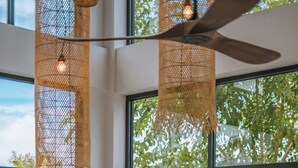 A modern interior with a large sliding glass door leading to a balcony with lush greenery.