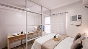 Un dormitorio con cama, escritorio y espejo.