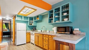 A kitchen with wooden cabinets, a white refrigerator, a stove, and a microwave. - Shared Backyard Oasis • Hot Tub + Grill (Moab)