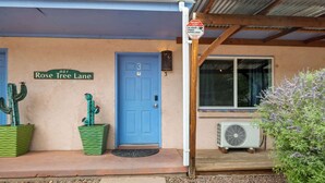 A building with a blue door, a sign reading "Rose Tree Lane," and two green planters with cacti. - Adventure Base • Hot Tub • Grill • Close to Town (Moab)