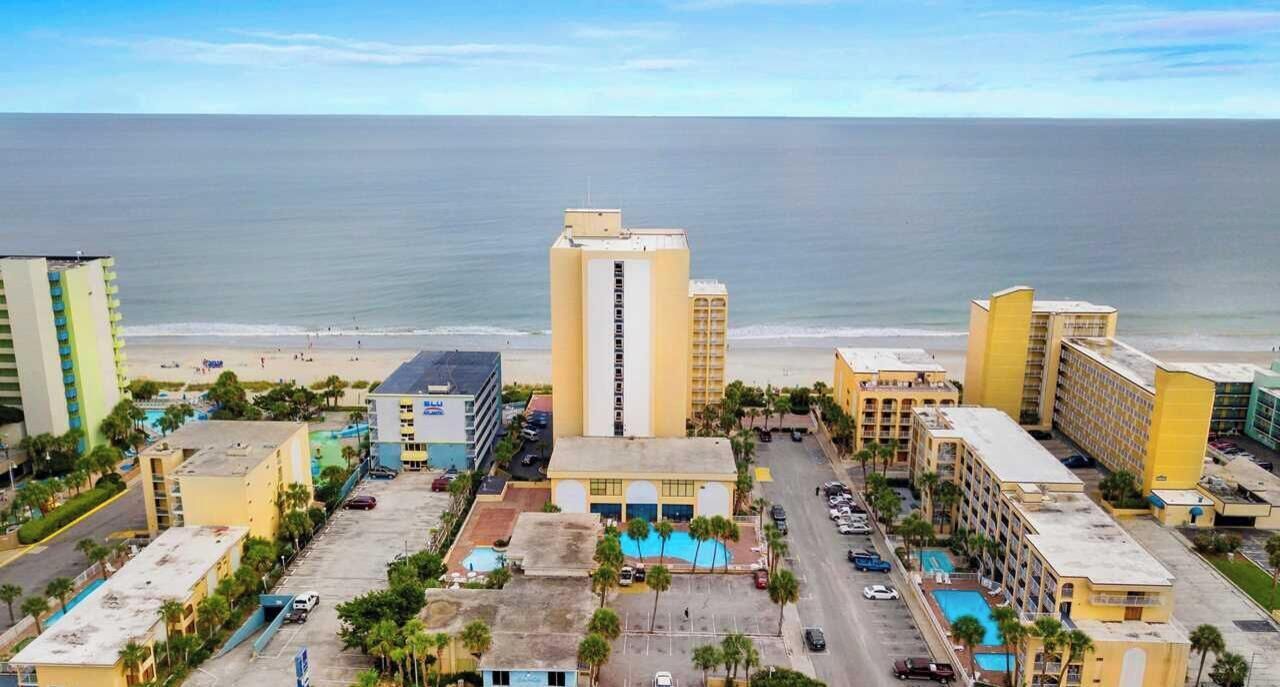 Ein Hotel an der Küste mit Pool, Parkplatz und Blick auf Strand und Meer.