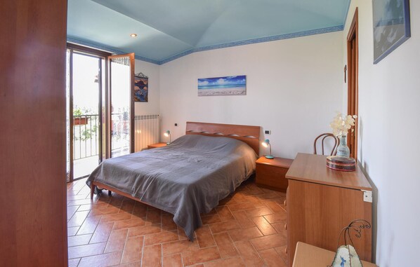 A bedroom with a bed, bedside tables, a dresser, a window, and a painting on the wall. - 1 bedroom gorgeous apartment in Montefiascone (Montefiascone)