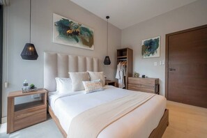 Ein modernes Schlafzimmer mit einem großen Bett, Nachttischen, einem Kleiderschrank und abstrakter Kunst an den Wänden.