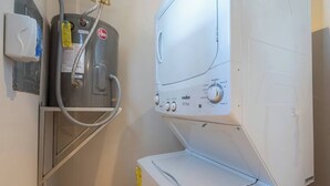 A laundry area with a water heater, a washing machine, and a dryer.