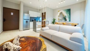 Una sala de estar moderna con un sofá, una mesa de centro de madera y un comedor con mesa y sillas.