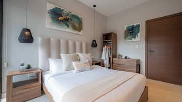 A bedroom with a large bed, bedside tables, a wardrobe, and abstract artwork on the walls.