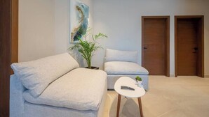 Una sala de estar moderna con un sofá, una mesita y una planta en maceta.