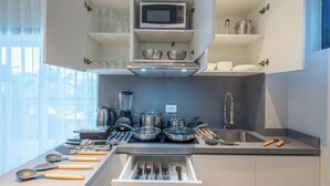 A modern kitchen with a microwave, stove, and various utensils.
