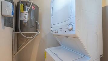 A laundry area with a water heater, a washing machine, and a dryer.