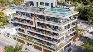 A multi-story hotel with a rooftop pool, balconies, and a modern architectural design.