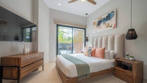 Ein Schlafzimmer mit einem Bett, einem Holzschrank, einem Fernseher und einem Deckenventilator.