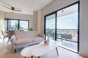 Una sala moderna con un sofá, una mesa de centro y un balcón con vistas.