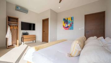 A modern bedroom with a large bed, a wooden wardrobe, a flat-screen TV, and a painting on the wall.