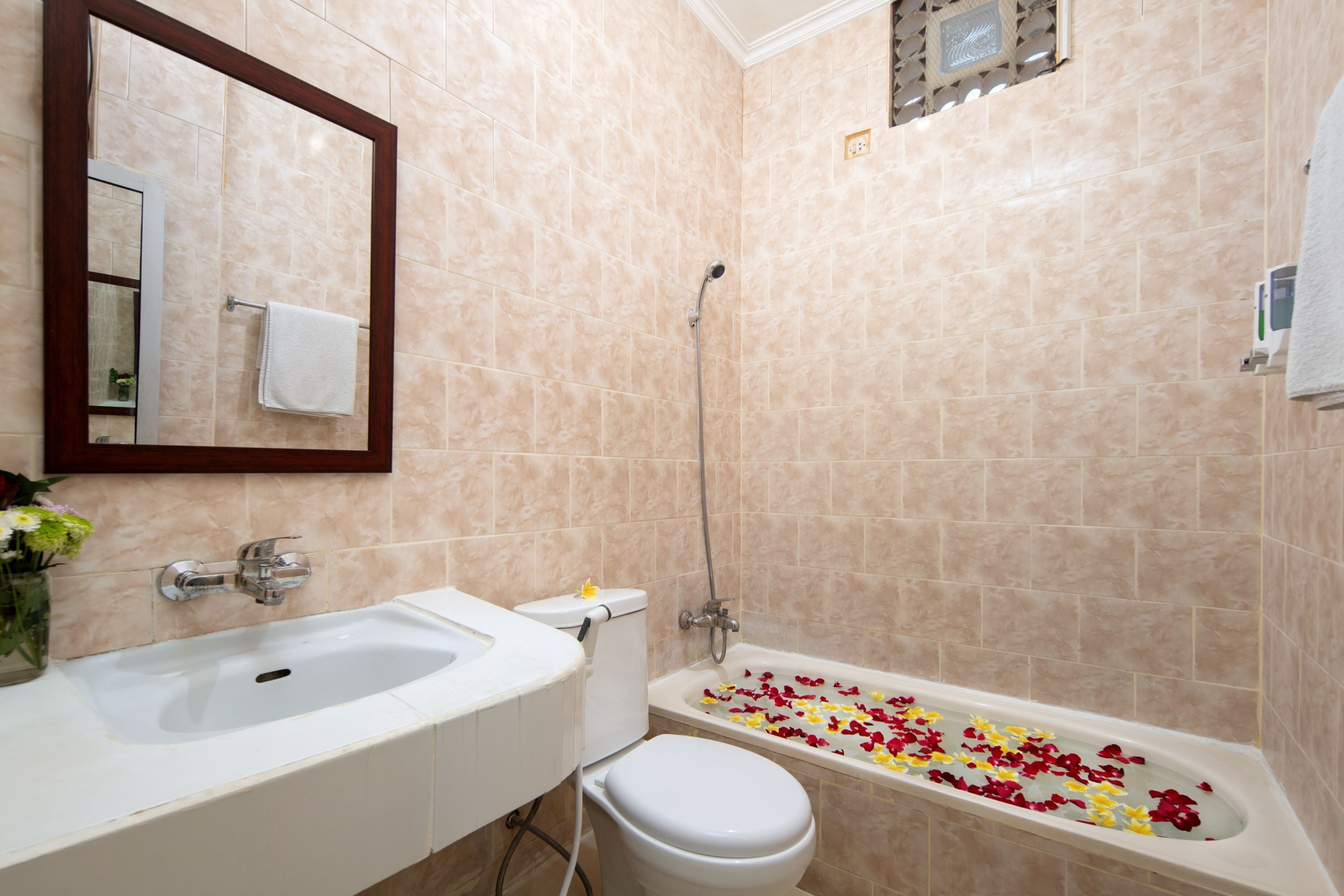 A bathroom with a bathtub, sink, toilet, and mirror.
