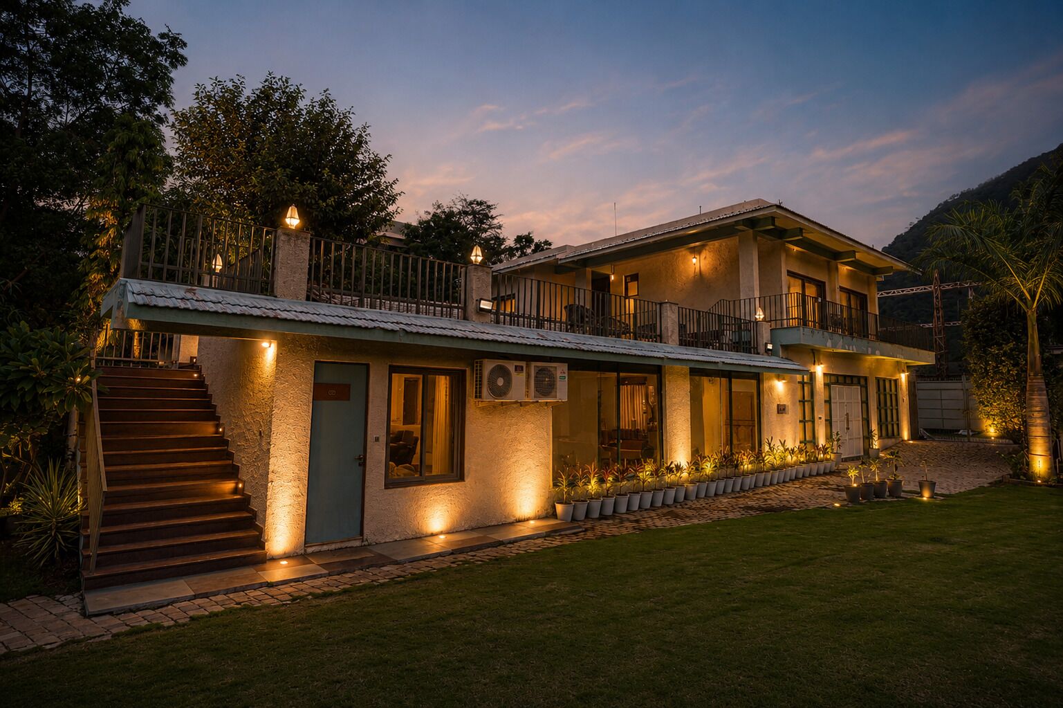 A two-story house with a balcony, a staircase, and a well-lit entrance.
