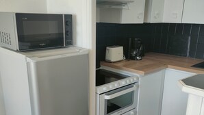 A compact kitchen with a refrigerator, microwave, toaster, and oven. - Studio Quiberon Face Mer vue sur les Îles (Quiberon)