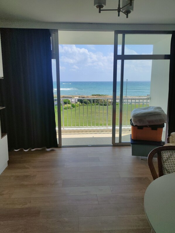 A room with a view of the ocean, a sliding glass door, a bed, and a table. - Studio Quiberon Face Mer vue sur les Îles (Quiberon)