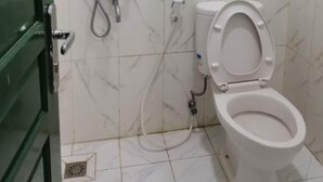 Ein Badezimmer mit Toilette, Dusche und einer grünen Tür.