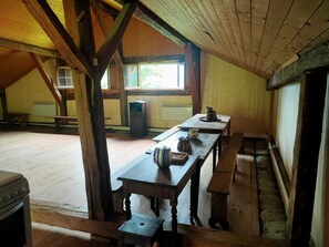 Un comedor rústico de madera con una larga mesa, bancos y una ventana que proporciona luz natural.