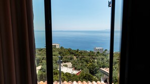 Vista desde un balcón sobre una zona costera con edificios y vegetación.