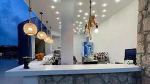Un área de bar moderna con una pared de acento de piedra, iluminación colgante y una pantalla grande.