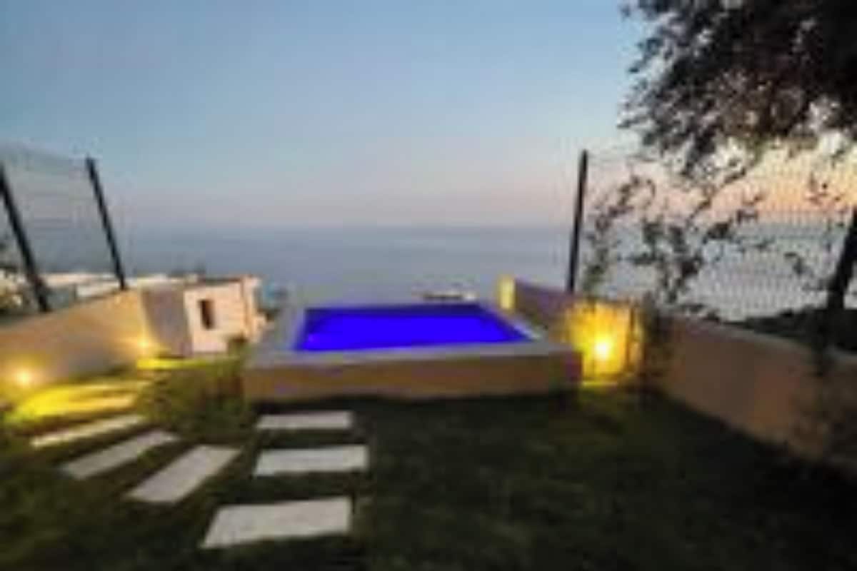 A swimming pool with a clear view of the sea in the background.