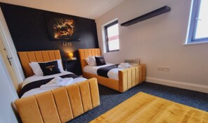 A hotel room with two beds, a black wall with a poster, a window, and a yellow rug. - Bull's Ring 3bed Penthouse City Centre (Birmingham)