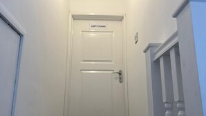 Een witte deur met een bord waarop 'LOFT STUDIO' staat.