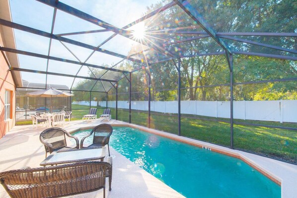 Relax by the pool surrounded by lush greenery and a clear view of the surrounding landscape.