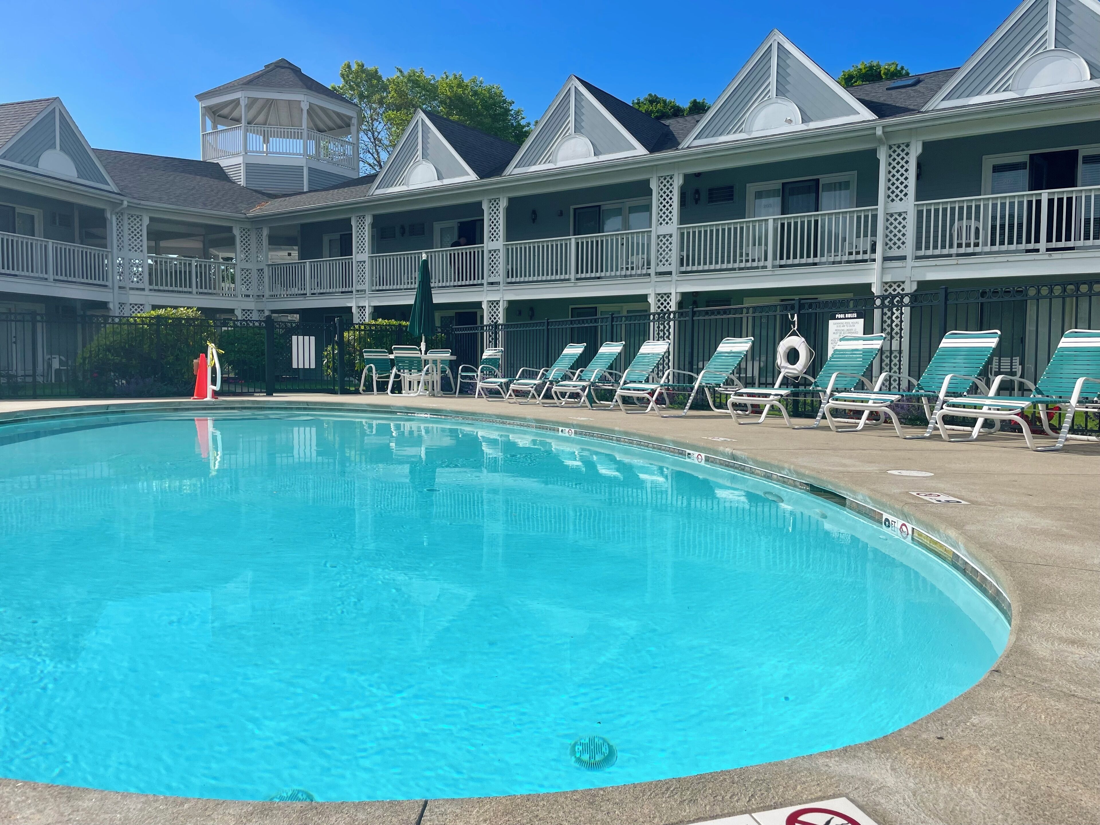 Un espace piscine avec des chaises longues et un coin salon abrité.