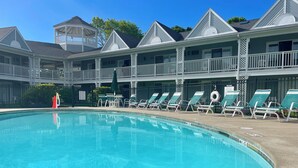 A pool area with lounge chairs and a covered seating area. - Ocean Towers 111 Condo (Ogunquit)