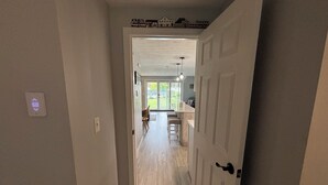 A hallway leading to a dining area with a view of the outdoors. - Ocean Towers 111 Condo (Ogunquit)