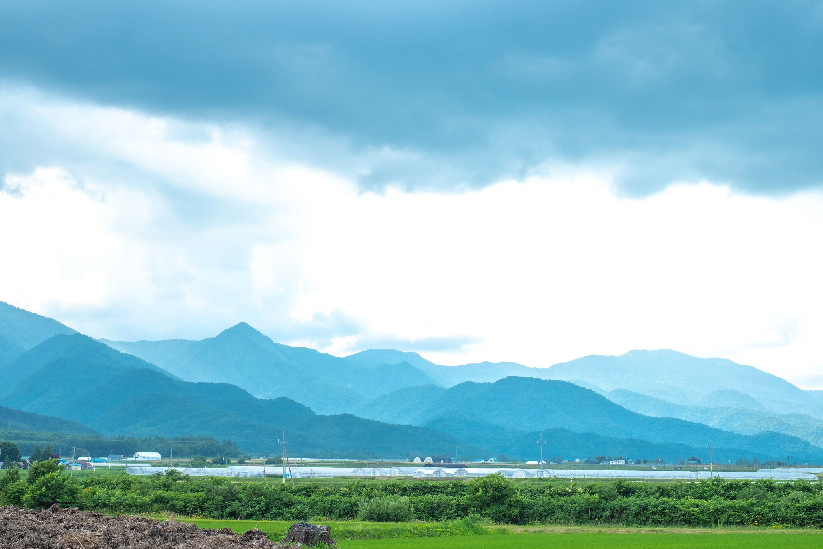 A mountainous landscape with green fields and a distant building.