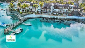 Un complejo turístico costero con muelle, barcos y espigón.