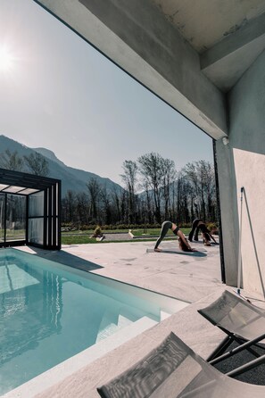 Un espace piscine extérieur moderne offrant une vue dégagée sur les montagnes en arrière-plan.