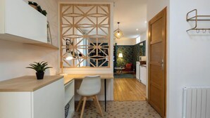 Una cocina compacta con mostrador de madera, una silla blanca y piso estampado.