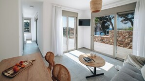A modern living room with a dining area, a sofa, and a table with fruit. - Boutique villa with private pool in Alonissos island, Greece. Stunning sea view. (Votsi)