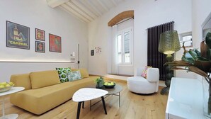 A modern living room with a yellow sofa, a white armchair, a small white table, and a potted plant. - Santa Croce Gem w/ Chic Decor & Historic Charm (Florence)
