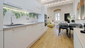 A modern kitchen with white cabinets, a stainless steel sink, and a ceiling with recessed lighting. - Santa Croce Gem w/ Chic Decor & Historic Charm (Florence)