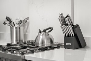 A kitchen with a gas stove, a kettle, a utensil holder, and a knife block. - The Adaline #8 - Luxury Second Floor Bayshore Apt! (Tampa)
