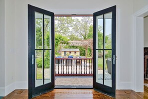 A room with a large glass door leading to an outdoor patio with a wooden deck and a pergola. - Sur la Mer: Ocean views in Rockport (Rockport)