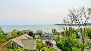 Un quartier résidentiel situé sur la côte, avec des maisons, une vue dégagée sur la mer et une végétation luxuriante.