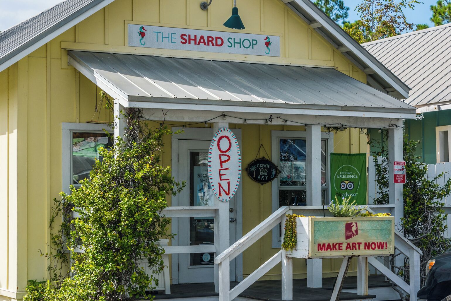 A yellow building with a sign reading "The Shard Shop" and an "OPEN" sign.