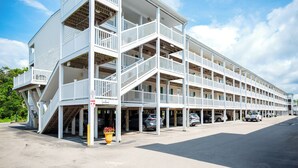 Um estacionamento de vários andares com grades brancas e céu claro.